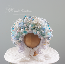 Load image into Gallery viewer, Light blue and white flower bonnet, Christmas theme, size 9-24 months old, photography prop. Bonnet placed on wooden ball