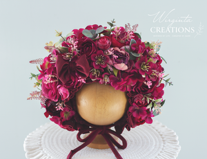 Flower bonnet on a wooden ball stand. For 12-24 month sold, photography prop for kids. Made using burgundy artificial flowers
