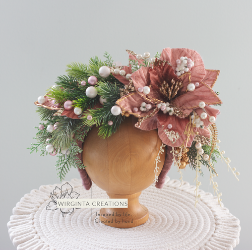 Christmas-inspired flower headband, colours: green, mauve, gold, white. Headband placed on wooden oval stand. Creator-Wirginta Creations. Photography prop.