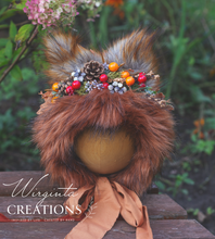 Load image into Gallery viewer, Decorated fox bonnet with artificial berries, faux fur and greener. Photography prop headpiece for 9-24 months old. Bonnet is placed on a wooden ball, green outdoor background. Creator - Wirginta Creations