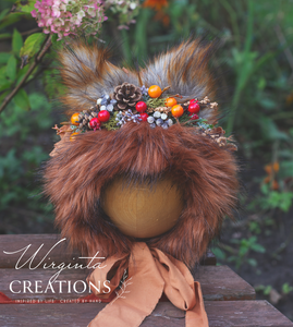 Decorated fox bonnet with artificial berries, faux fur and greener. Photography prop headpiece for 9-24 months old. Bonnet is placed on a wooden ball, green outdoor background. Creator - Wirginta Creations