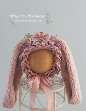 Load image into Gallery viewer, Tattered style bunny bonnet, handmade, mauve colour, faux fur ears, knitted base. Bonnet placed on a wooden ball stand. Wirginta Creations the creator. Size: 6-24 months old, photography prop. Easter
