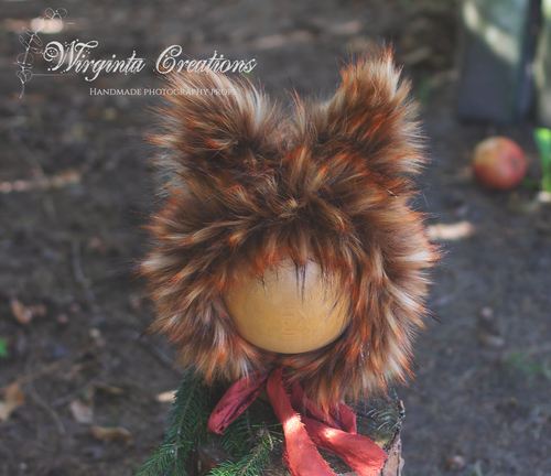 Fox bonnet for photography. Size 12-24 months old. Burnt orange colour. Base is tattered and decorated with faux fur.