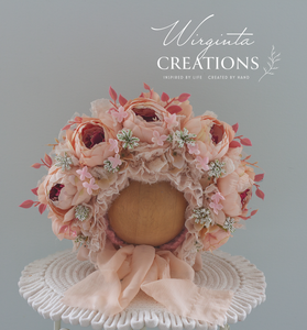 Light peach peonies flower bonnet for 12-24 months old placed on a wooden oval stand. artificial flower headpiece. Brand: Wirginta Creations