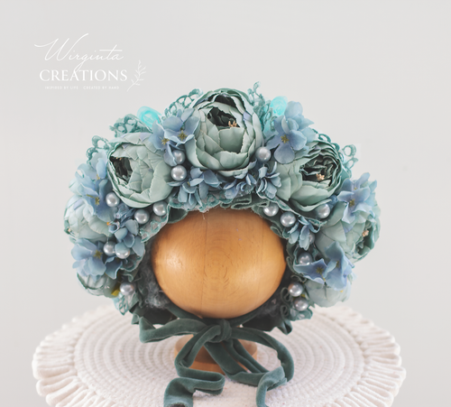 Turquoise colour flower bonnet placed on wooden ball stand. Decorated with velvet ties and pear beads. Peonies artificial flowers. Photography prop for   months olds. Brand: Wirginta Creations-