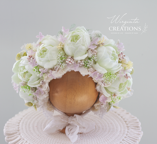 Light Green, White, Cream, Pale pink flower bonnet placed on wooden round stand. Photography prop for 12-24 months old. Lace ties. Brand: Wirginta Creations